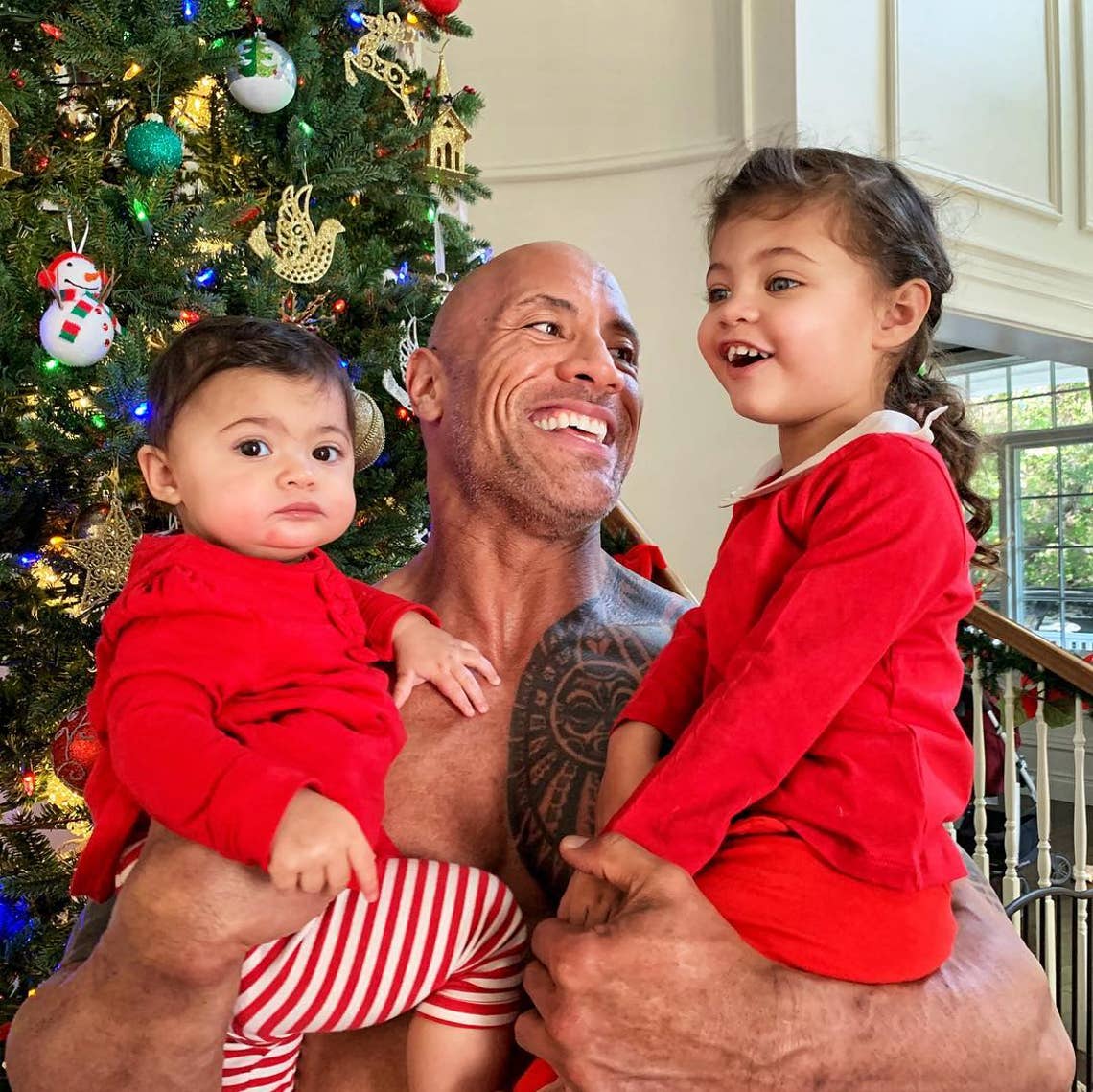 "Daddy’s arms. I ain’t gonna be able to hold ‘em like this forever, so you better believe I snatch these cookies and love ‘em up every moment I can. Plus, I know there’s gonna come a day where in daddy’s arms is the last place they want to be. Baby Tiana Gia is already there with the “help me” look on her face 😂🤦🏽‍♂️
Can’t guarantee I’ll love and protect all my daughters for the rest of their lives, but I can guarantee I will for the rest of mine. #xmas #daddysarms #helpme" Dwayne Johnson with youngest daughters Tiana and Jasmine